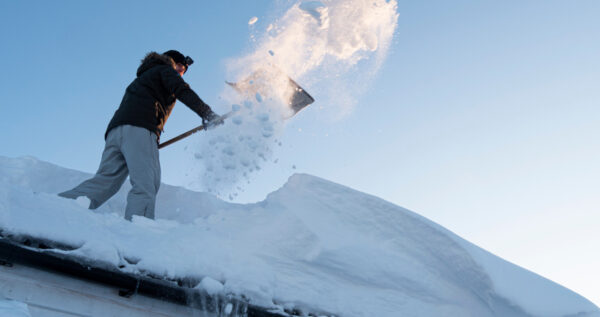 Man Shoveling Snow Off Wichita Home Roof